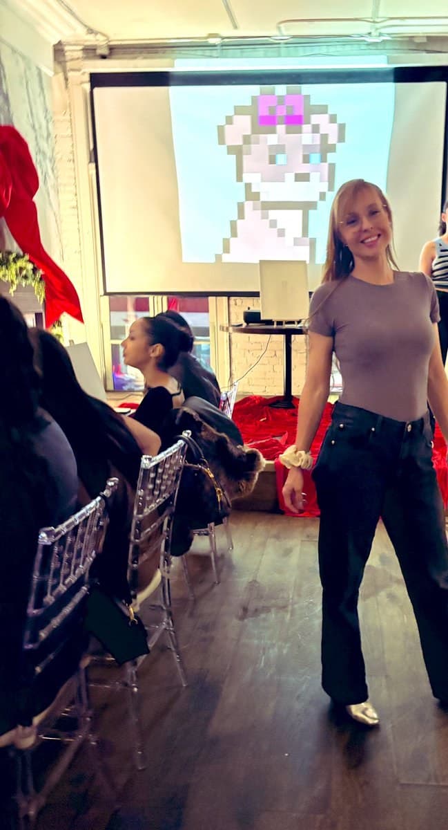 Leah Bluewater at an indoor Dogs event Leah Bluewater (@leahbluewater) at an indoor event with a pixel dog on screen