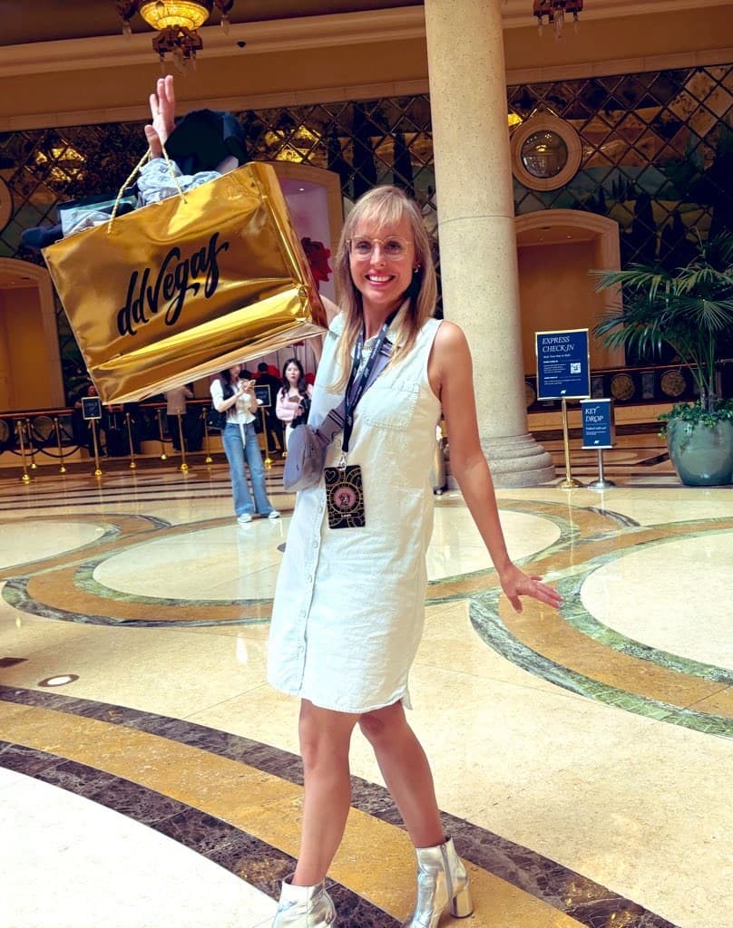 Leah Bluewater at ddVegas Leah Bluewater (@leahbluewater) in a hotel lobby holding a gold ddVegas bag